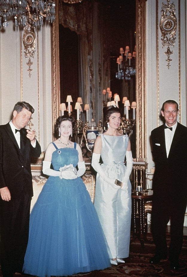 The Queen in a puffy blue gown next to Jackie&#x27;s light blue and sleek one