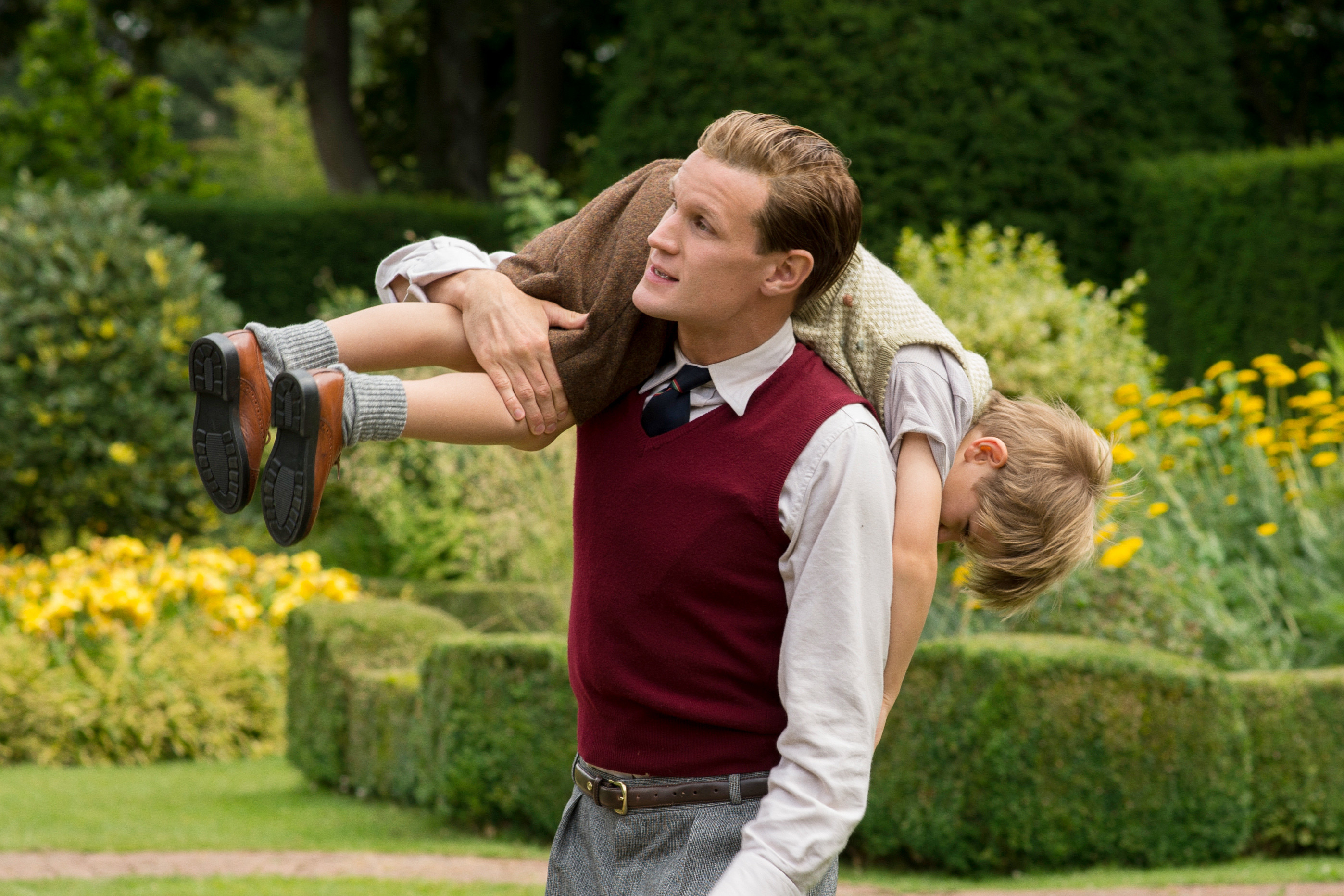 Matt Smith carrying a boy almost upside down in the show