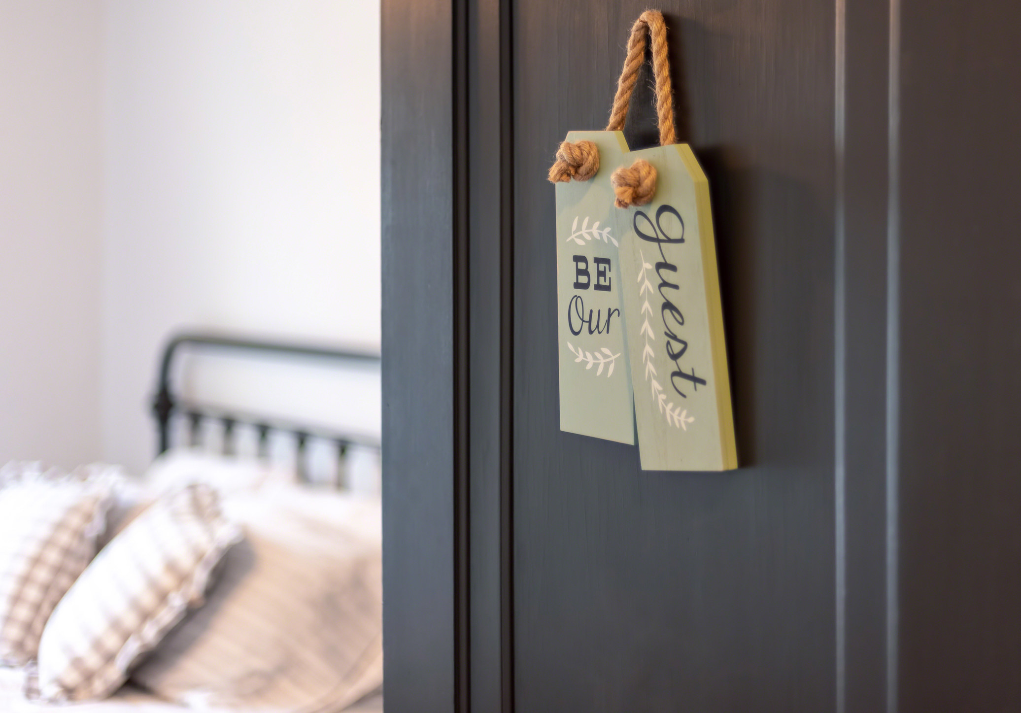 a bedroom with a "be our guest" sign on the door