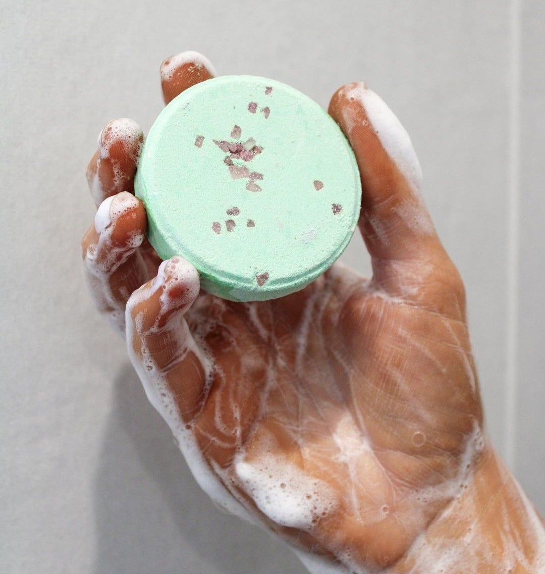 a person holding up one of the steamers in their soapy hand
