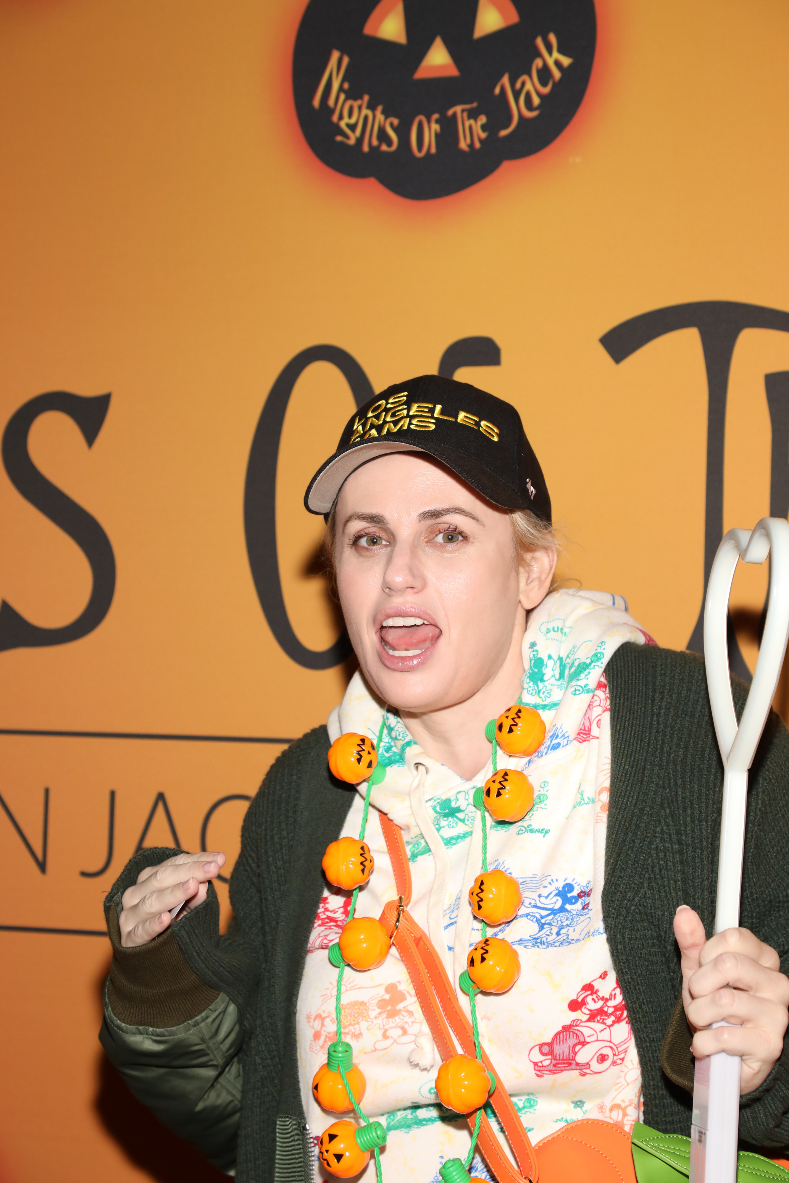 Rebel wearing a Jack-O-Lantern necklace as she makes a silly face at an event
