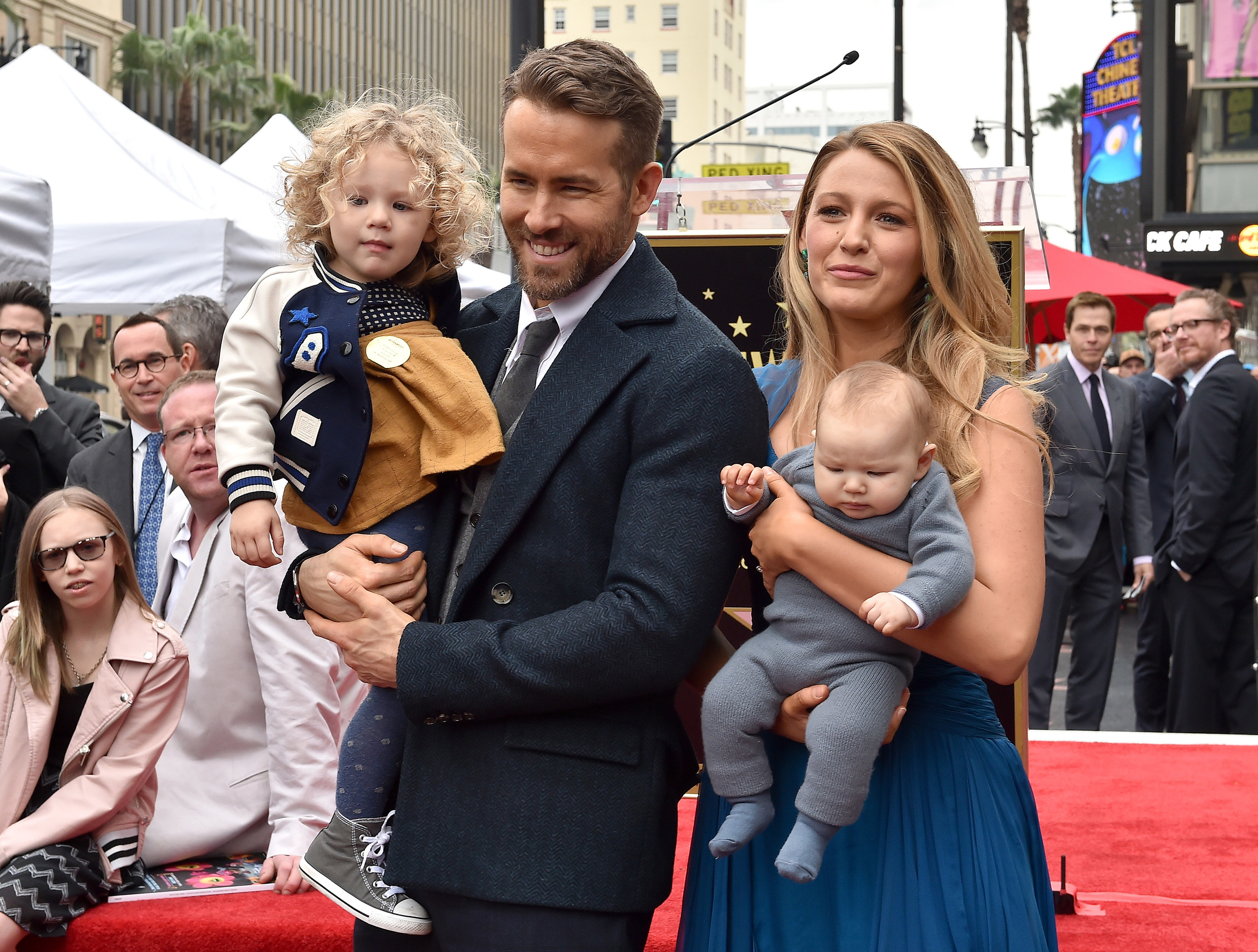Ryan and Blake hold two of their children on the red carpet