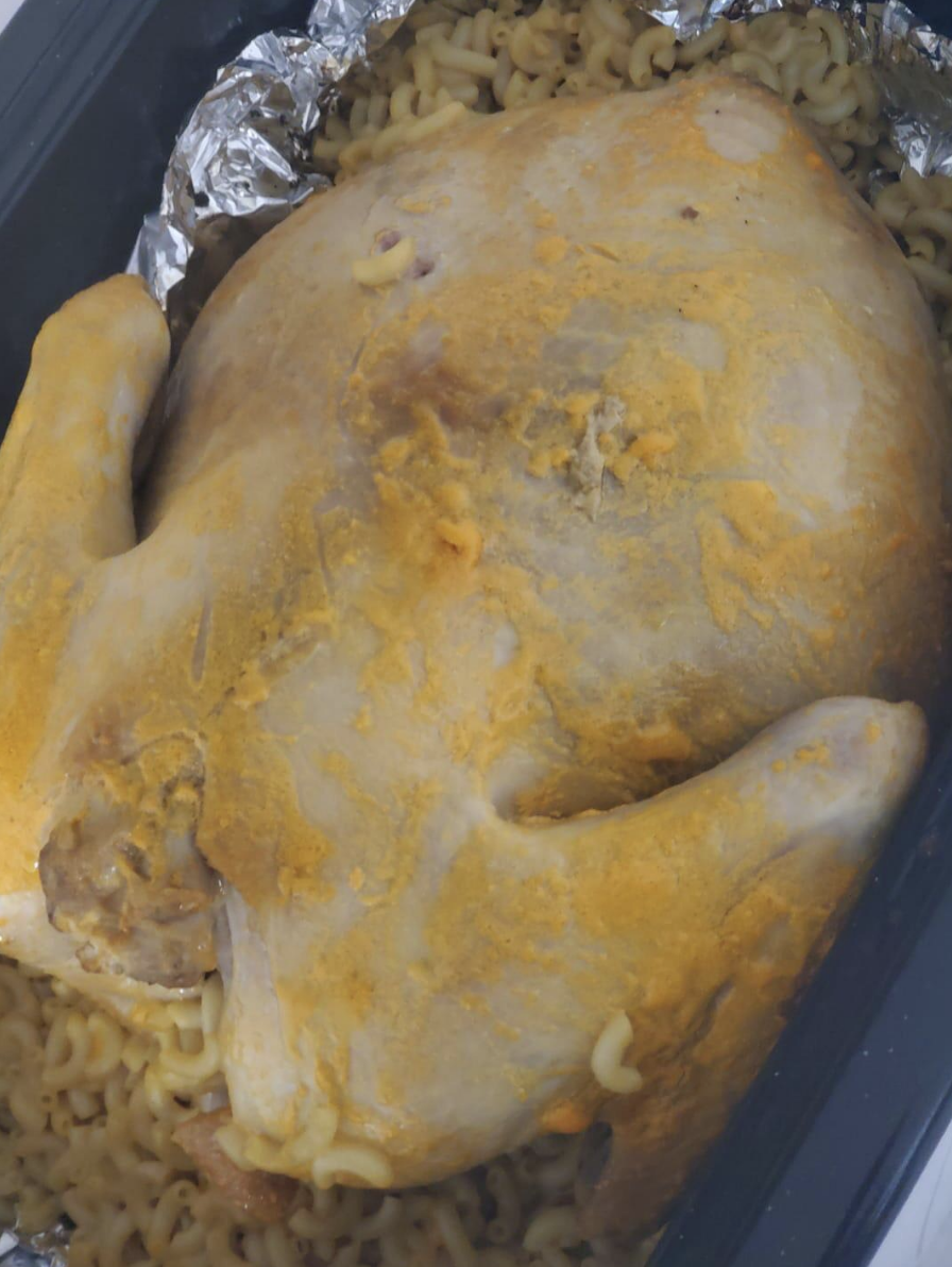 cheese-covered turkey on top of a pan of mac n cheese; the discoloration from the cheese makes the turkey look rotten