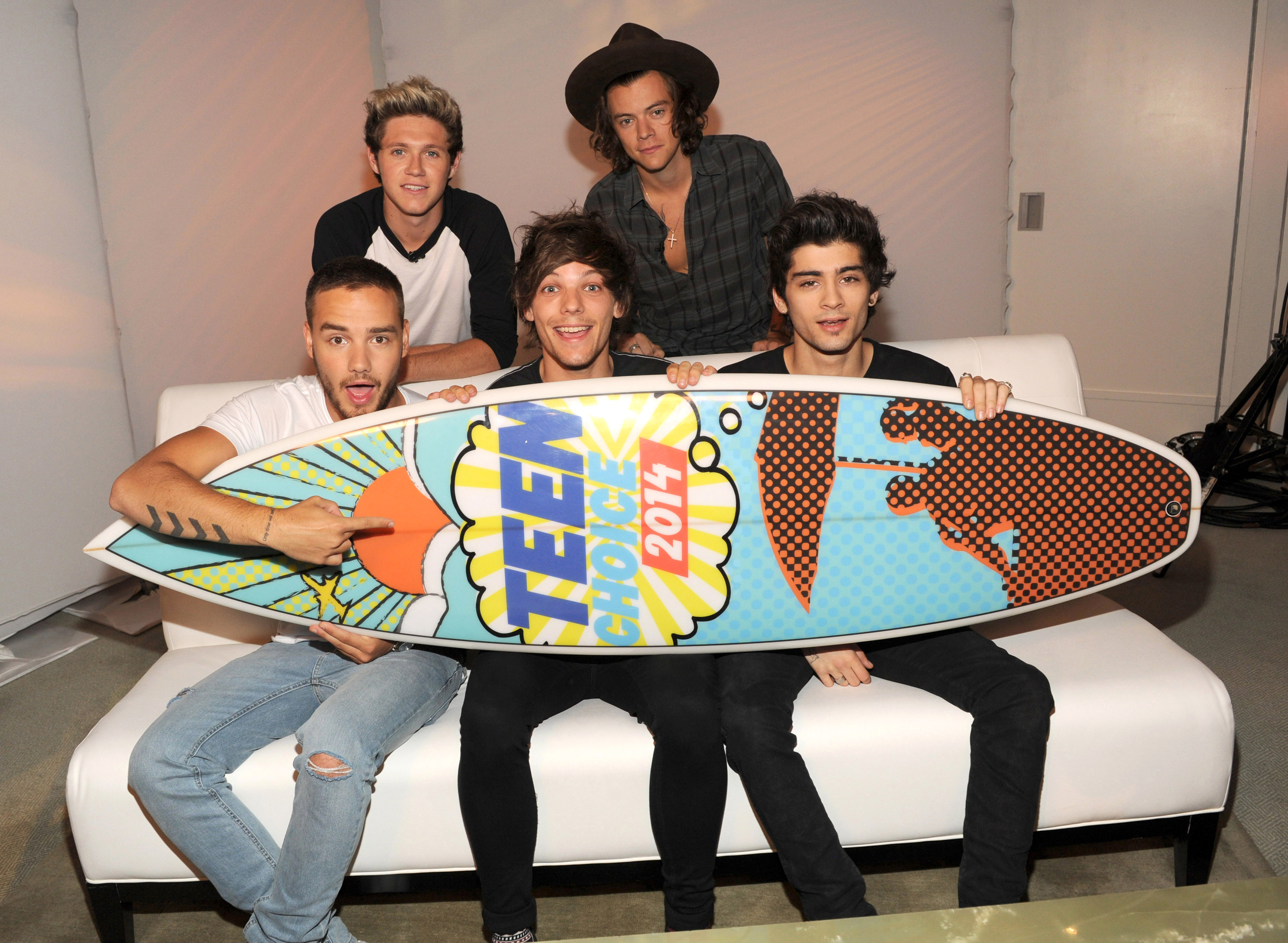 One Direction holding a surfboard