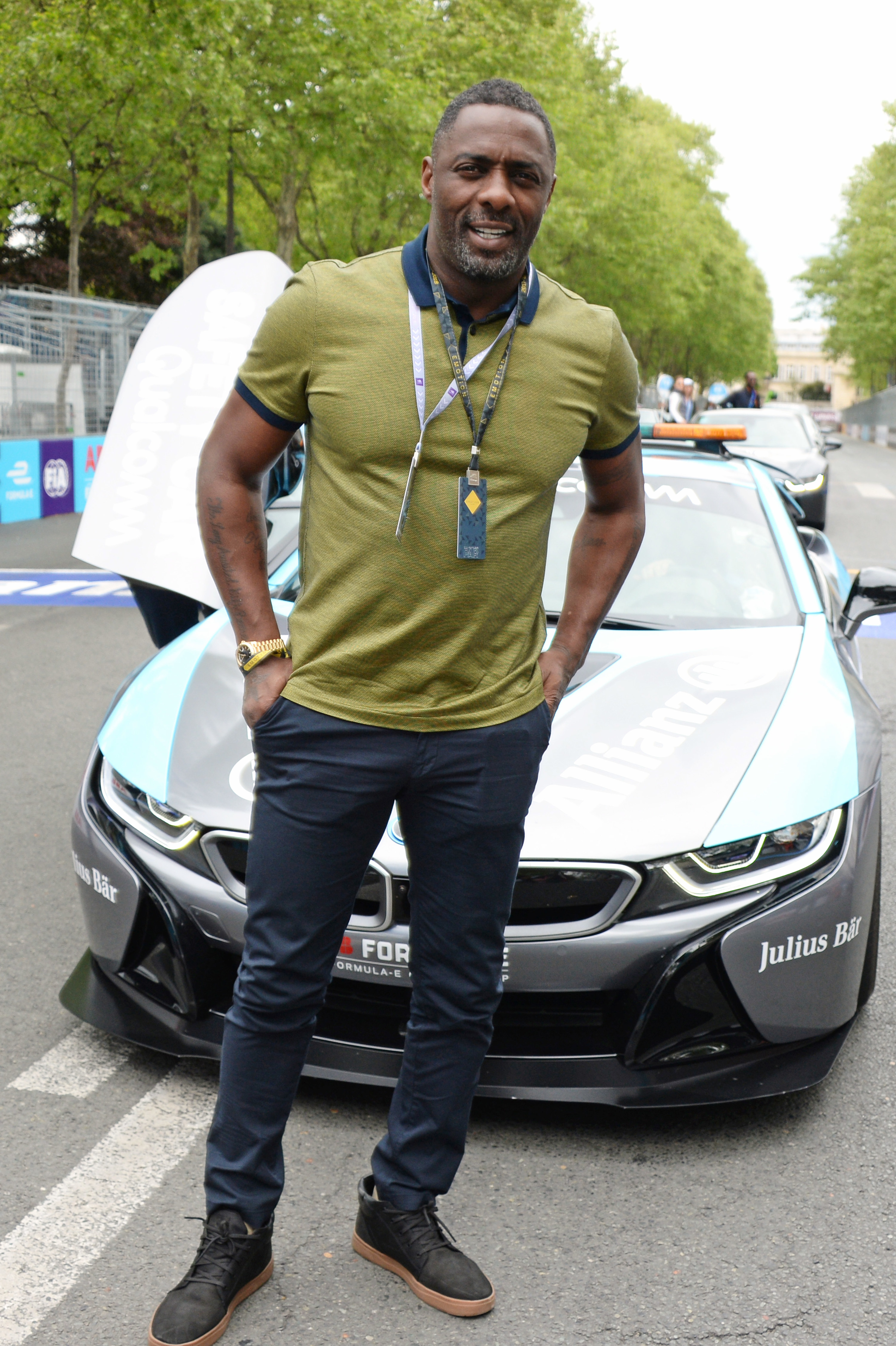 Idris Elba standing in front of a car