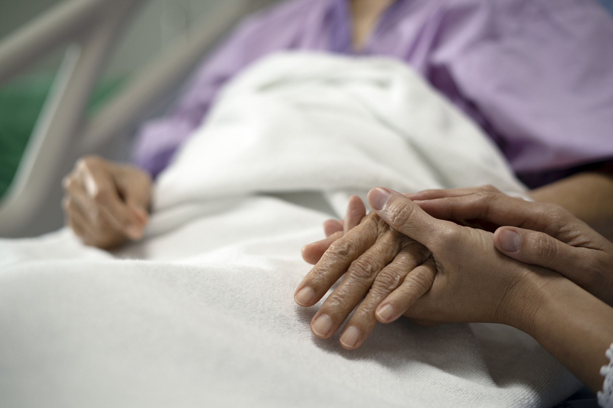 closeup of hands being held in the hospital bed