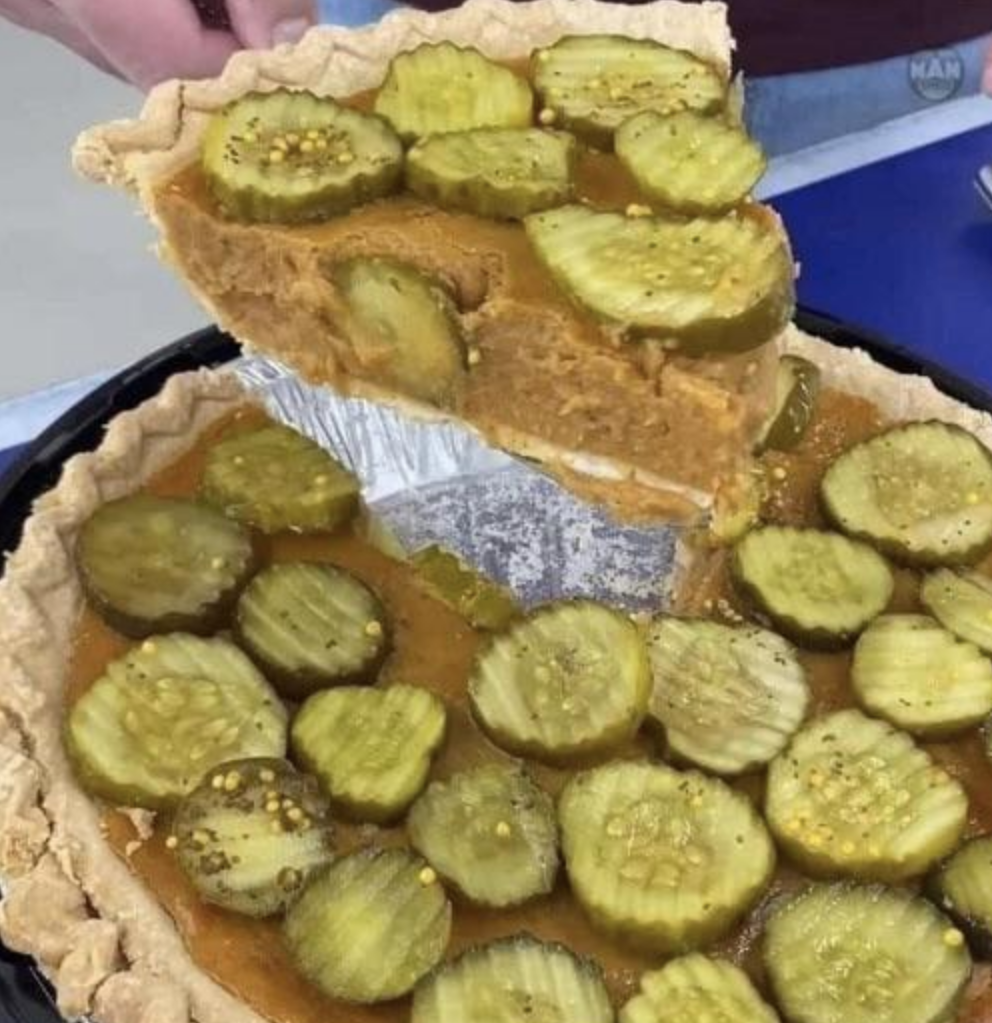 A normal pumpkin pie has been covered in sliced pickles