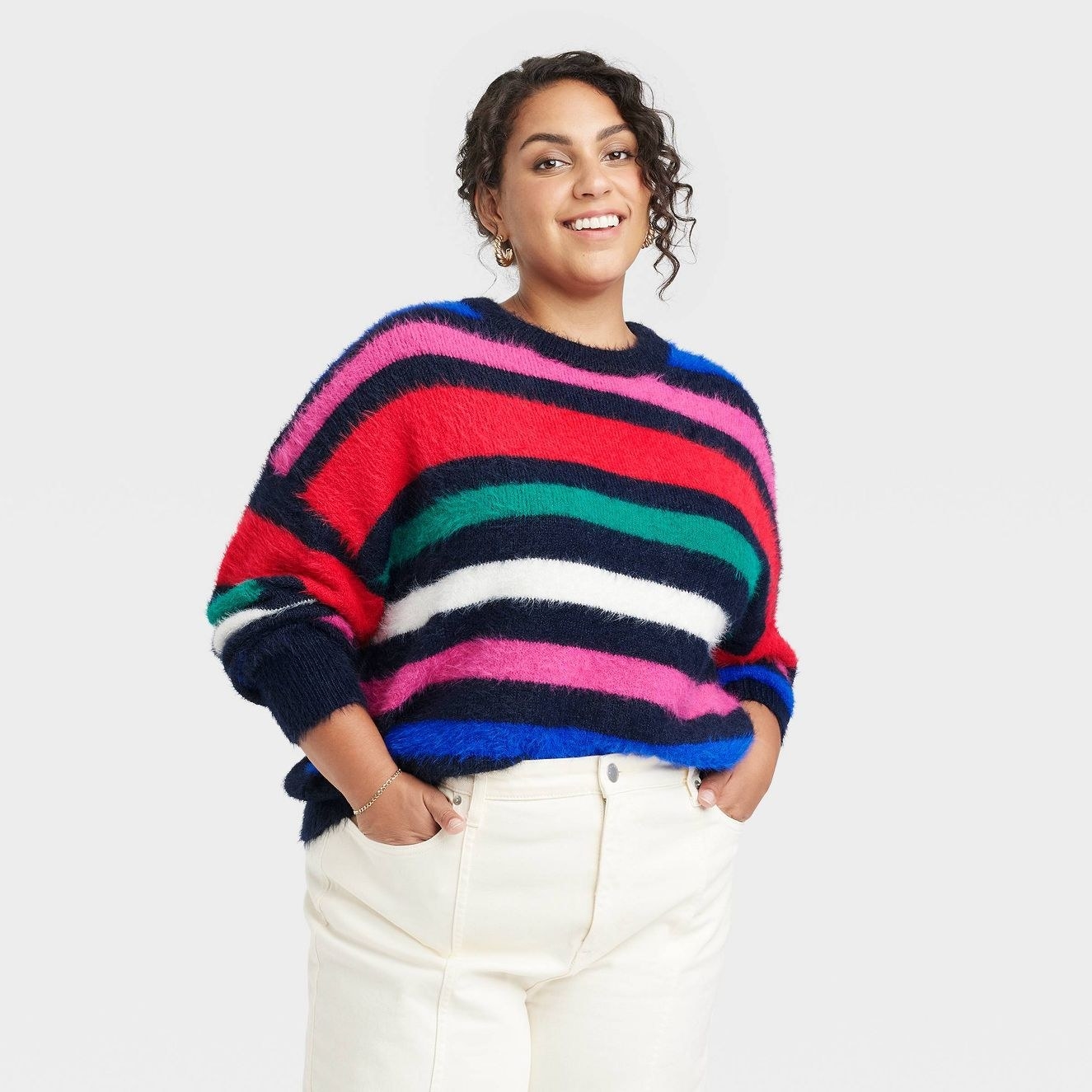 A model wearing the striped sweater with red pink black and blue stipes