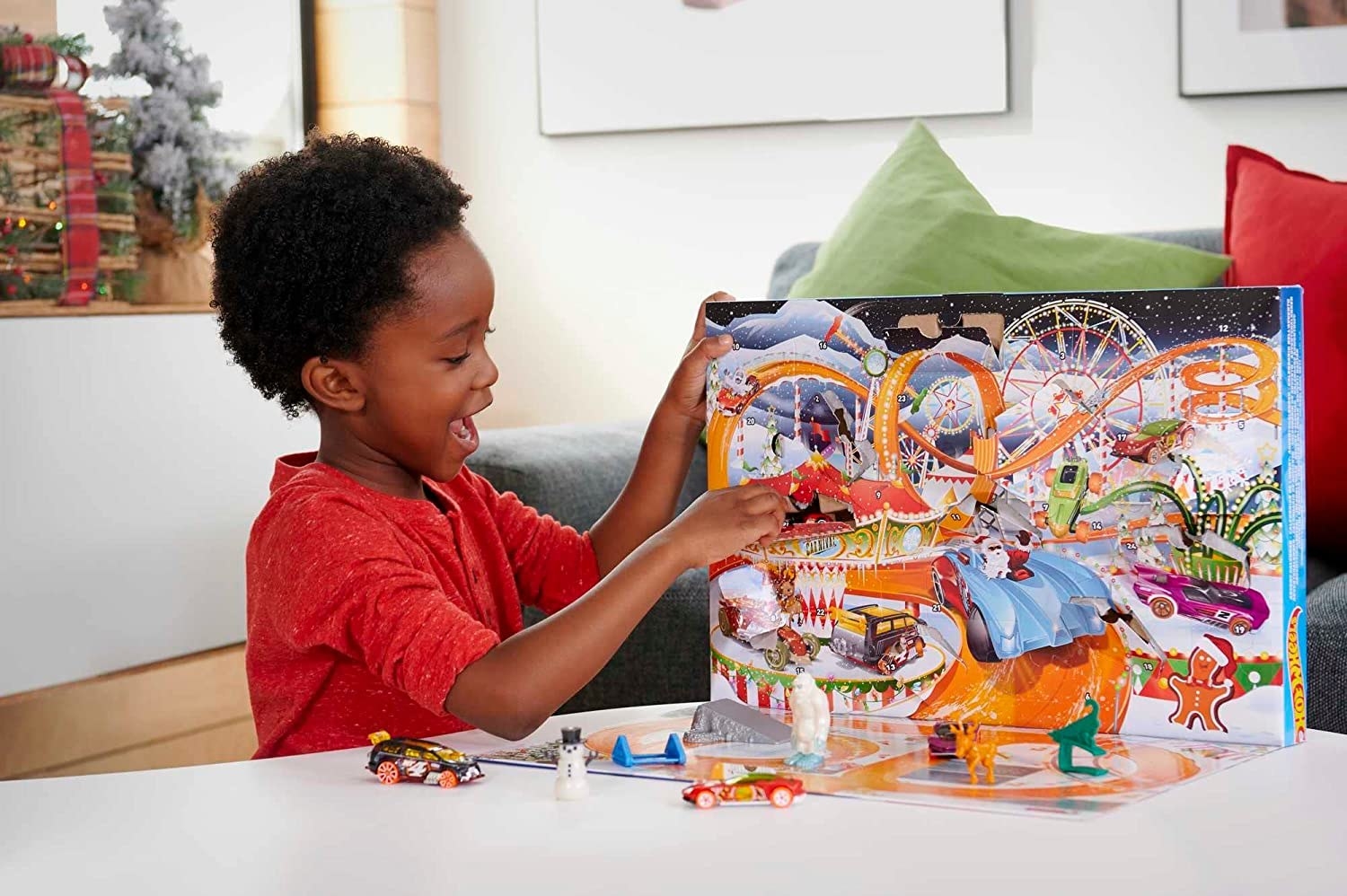 a boy playing with the hot wheels advent calendar