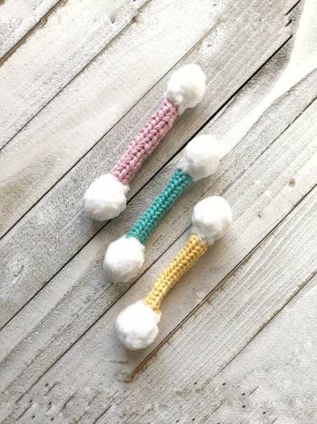 the cotton swab-shaped toy in pink, green, and yellow