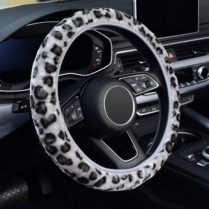 a leopard print fluffy steering wheel cover on a steering wheel
