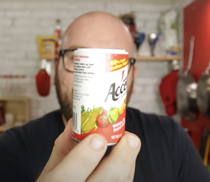 person holding up accent seasoning in a spice jar