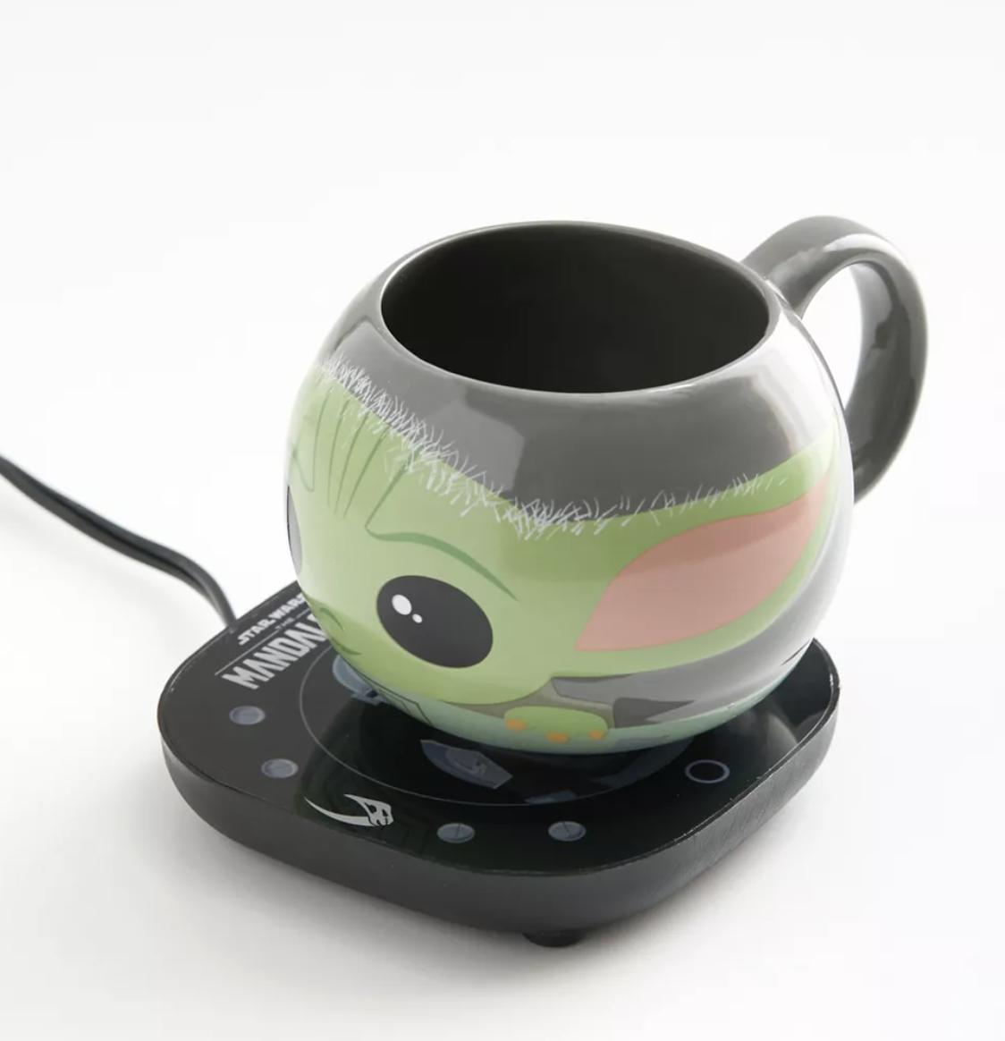 the mug on the warmer in front of a plain background
