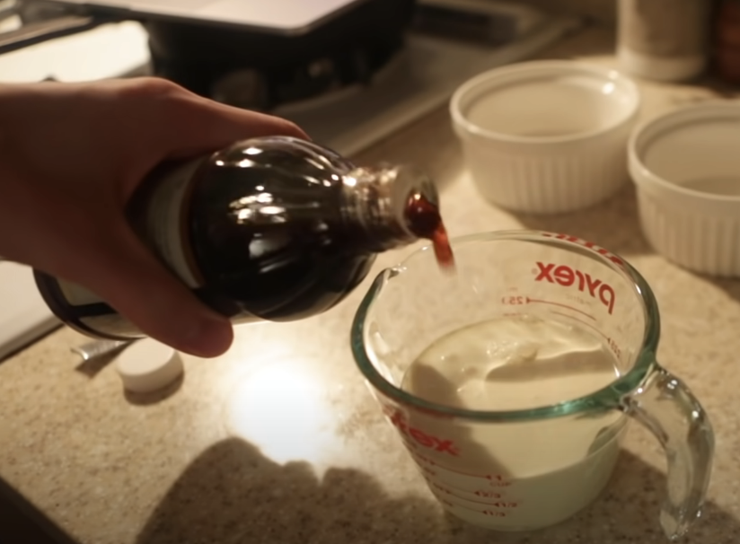 adding vanilla from bottle into cream in a measuring cup