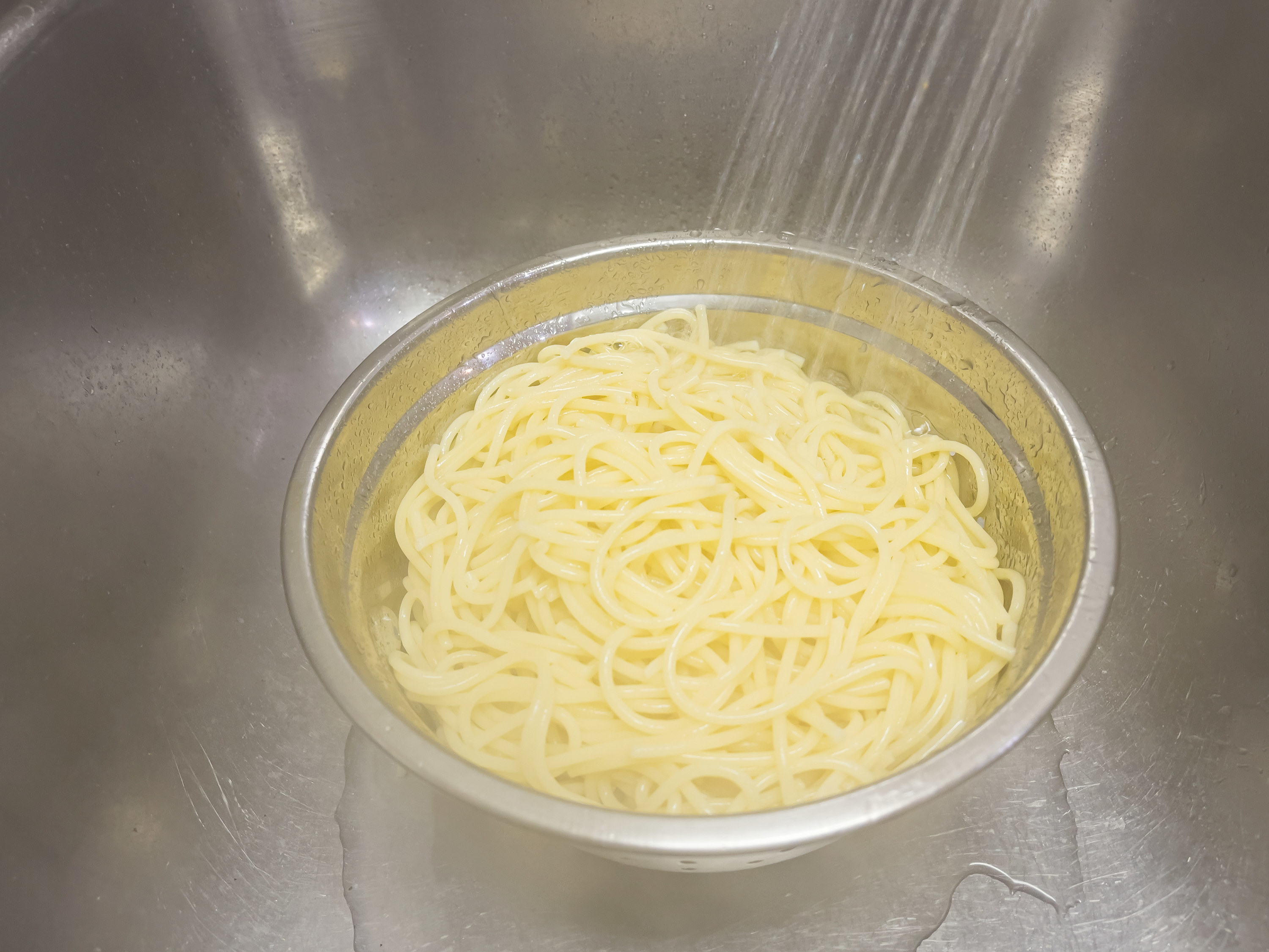 rinsing pasta under running water