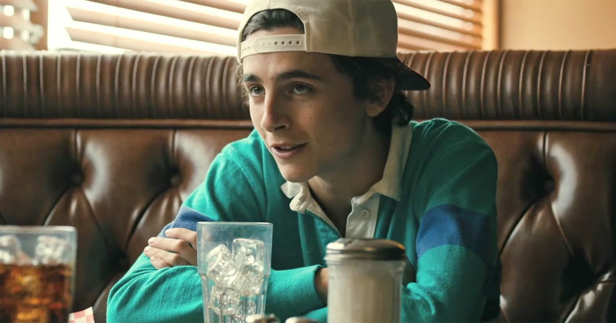 Timothee Chalamet sits in a booth at a restaurant