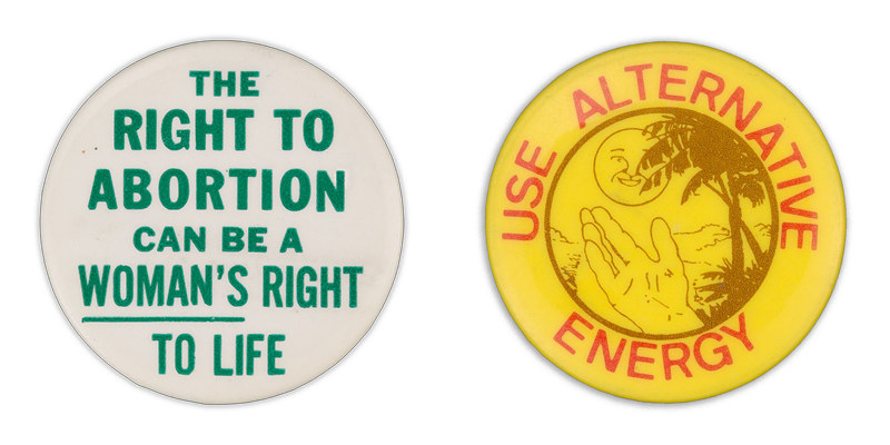 A button on the left reads &quot;The right to abortion can be a woman&#x27;s right to life&quot; with the word &quot;woman&#x27;s&quot; underlined; a button on the right shows an illustration hand gesturing toward a tree and smiling sun, encircled by the words &quot;use alternative energy&quot;