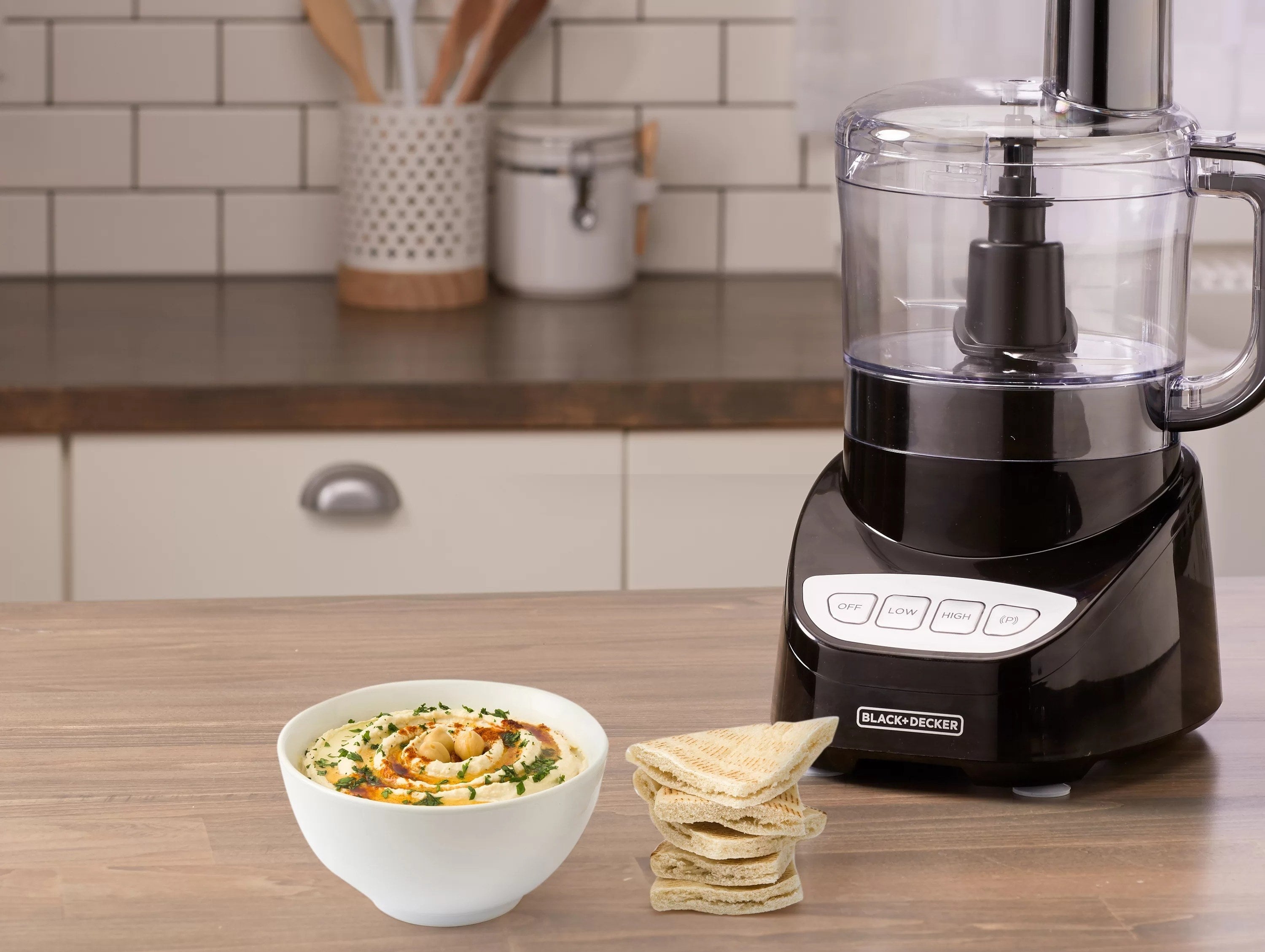 the food processor next to a bowl of hummus and pita bread