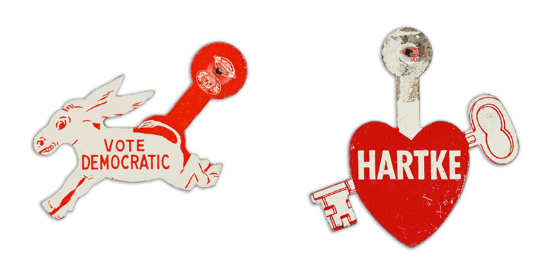 A button in the shape of a donkey reads &quot;vote democratic&quot; and a button outlined with a heart and a key going through it reads the name &quot;Hartke&quot;