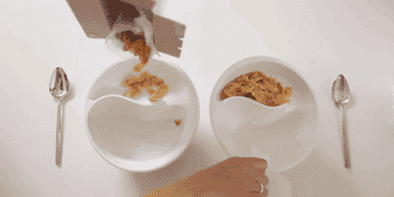 model pouring cereal and milk into a bowl and then spooning the cereal one side into the milk on the other side of the bowl