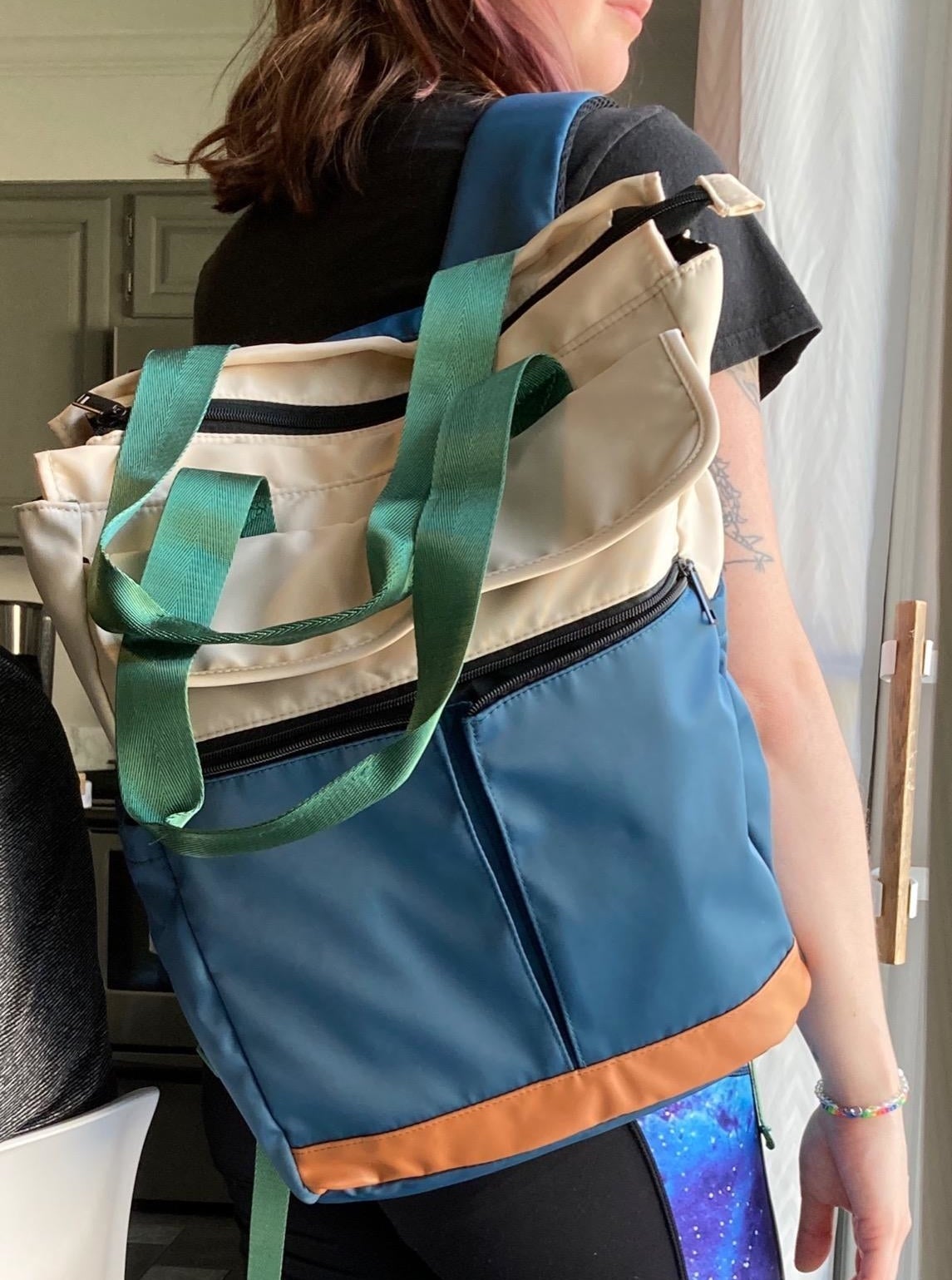 Reviewer with blue and white backpack slung over one shoulder