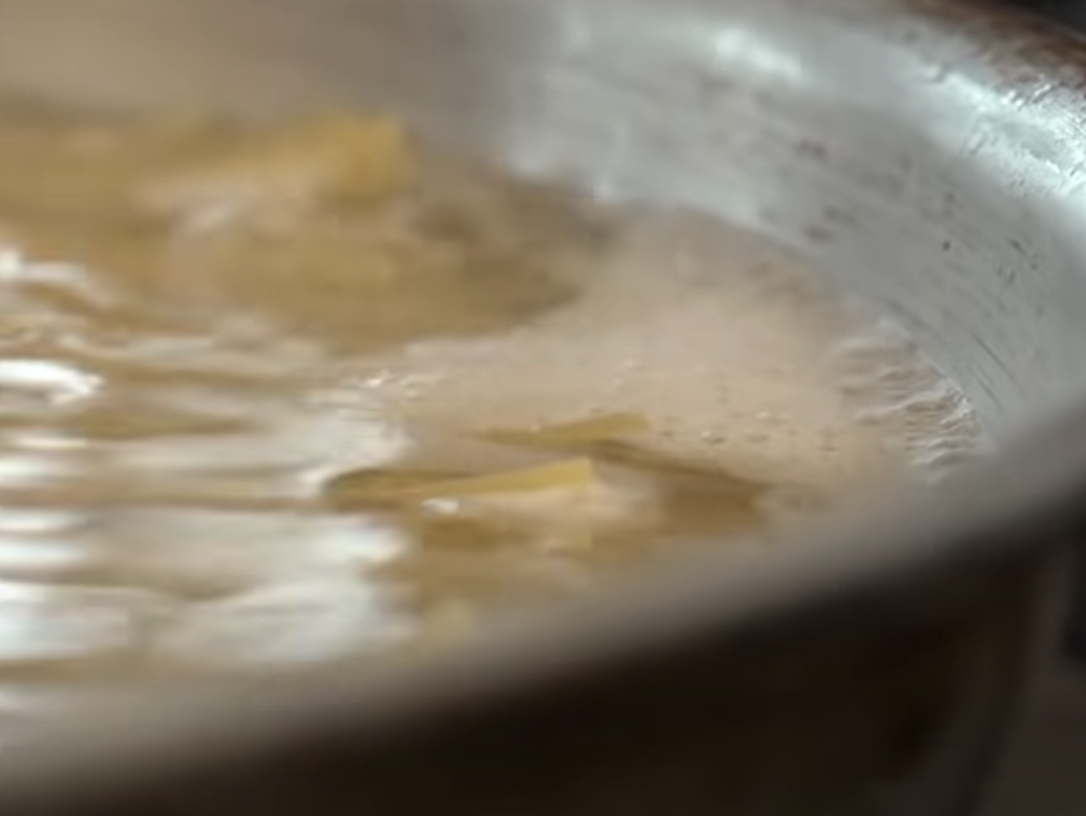 pasta cooking in a skillet with only a little bit of water covering it