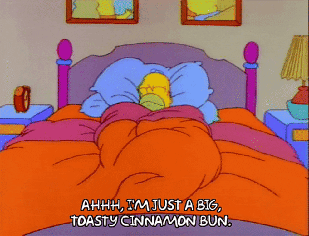 a gif of homer simpson snuggled in bed saying ahh, i&#x27;m just a big toasty cinnamon bun