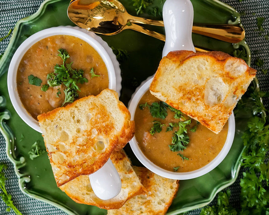 two bowls of soup with bread and parsley on top