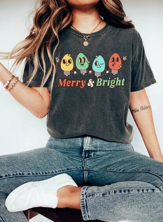 a model in a dark grey tee with smiley bulb lights on it and 