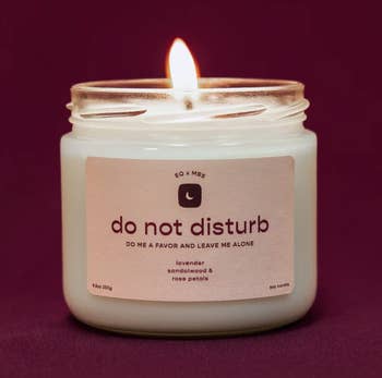 a candle with a pink label that says 