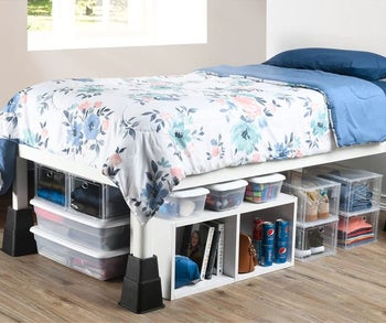 A bed with the bed risers attached to the legs, giving it room to fit a lot of storage underneath