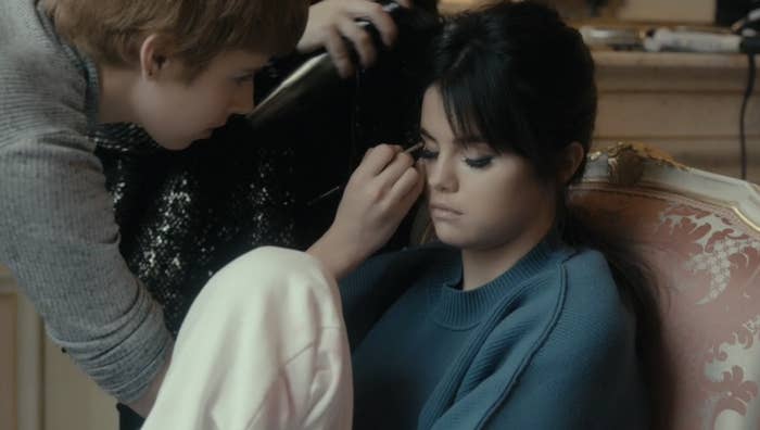 Selena sitting and getting her makeup done