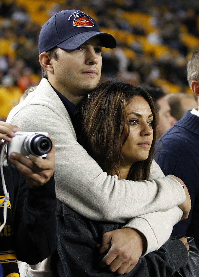 Ashton Kutcher and Mila Kunis look on from the sidelines before the game between the Chicago Bears and the Pittsburgh Steelers