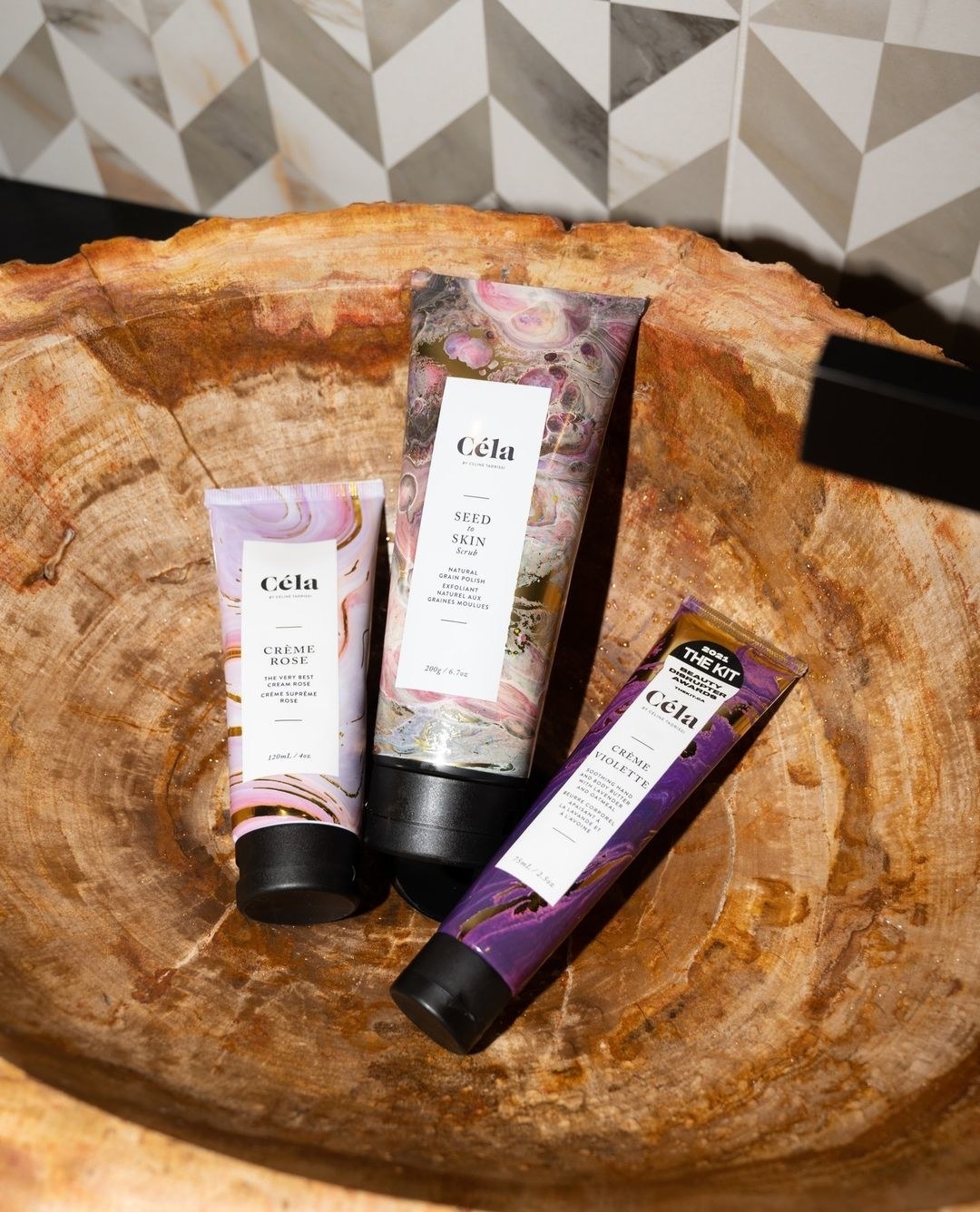 a trio of skincare tubes in a wooden sink