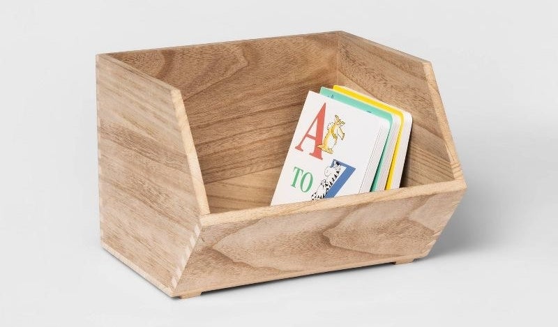 the wooden storage bin with books inside