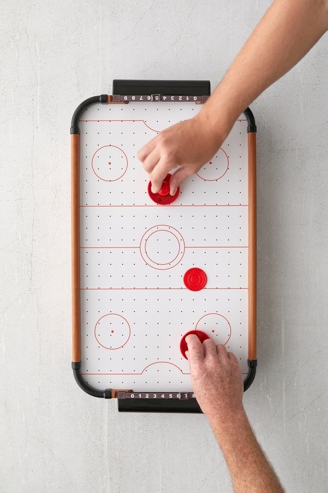 two people playing mini air hockey