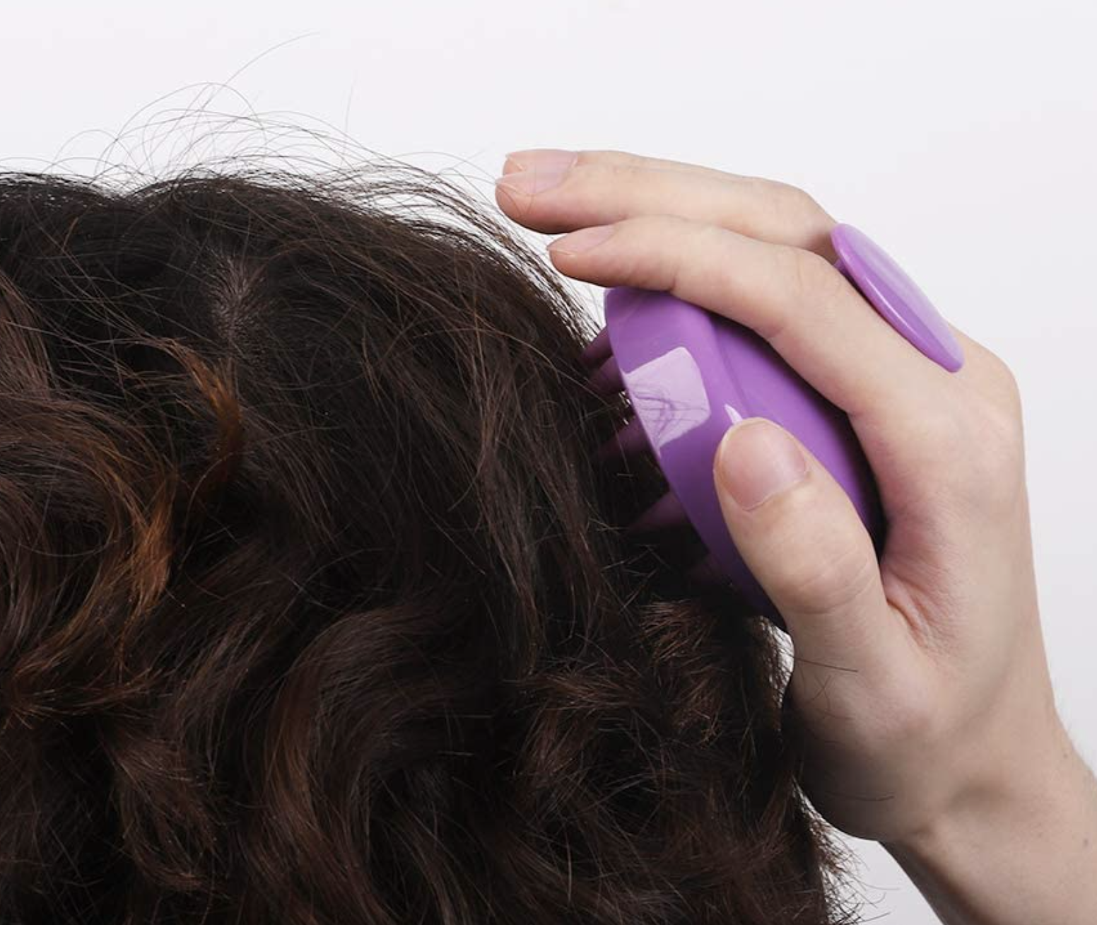 A person using the scalp brush in their hair