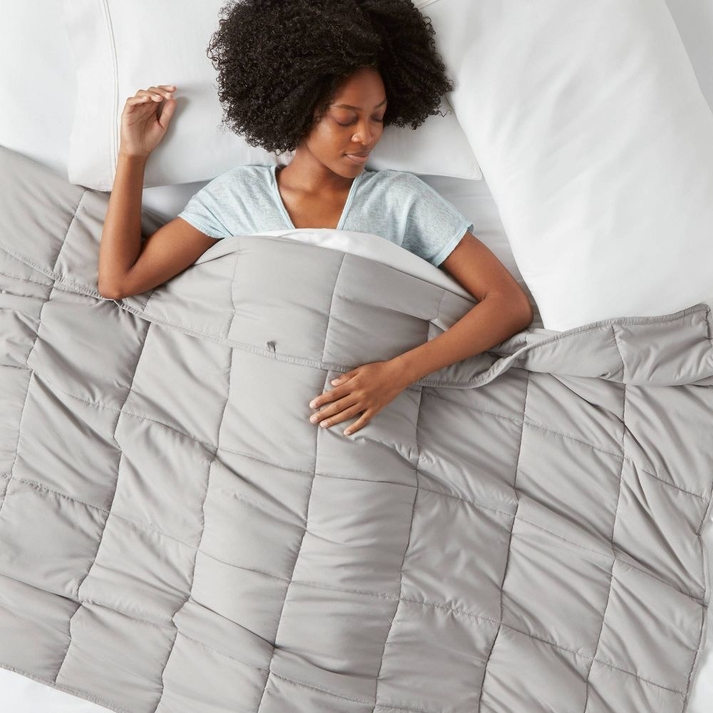 model under a quilter grey weighted blanket
