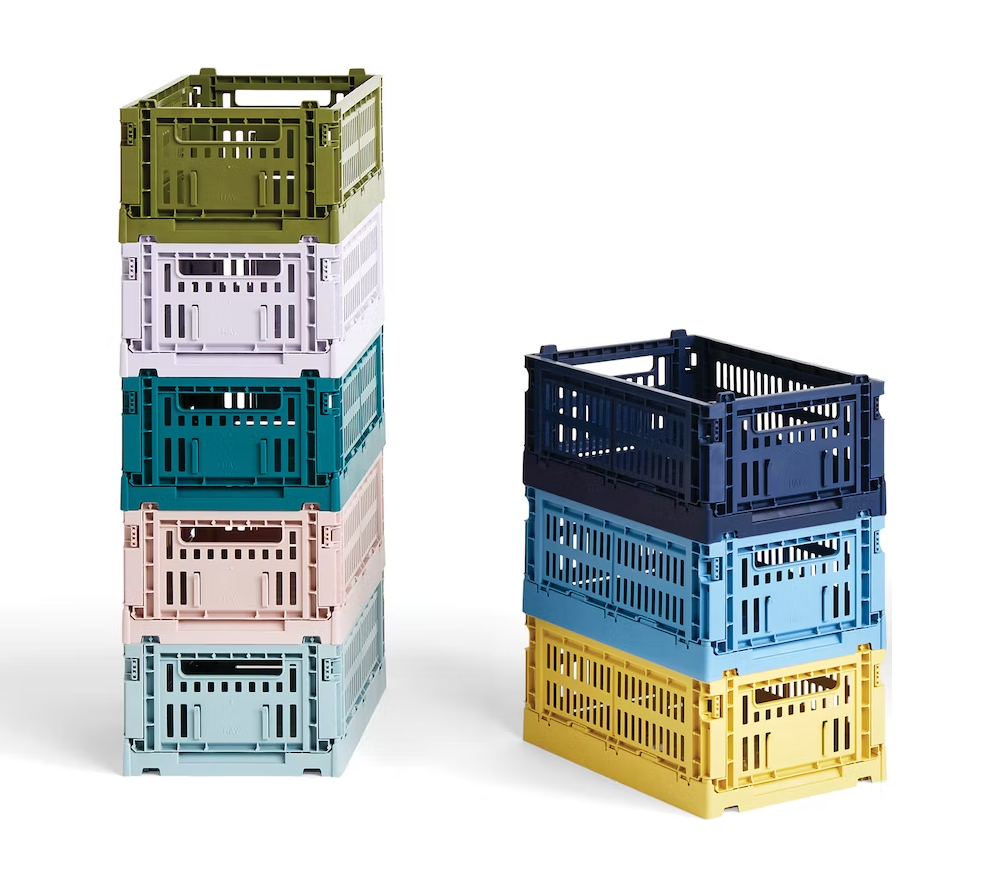 Colorful plastic bins that are stackable that have slots and hand holds