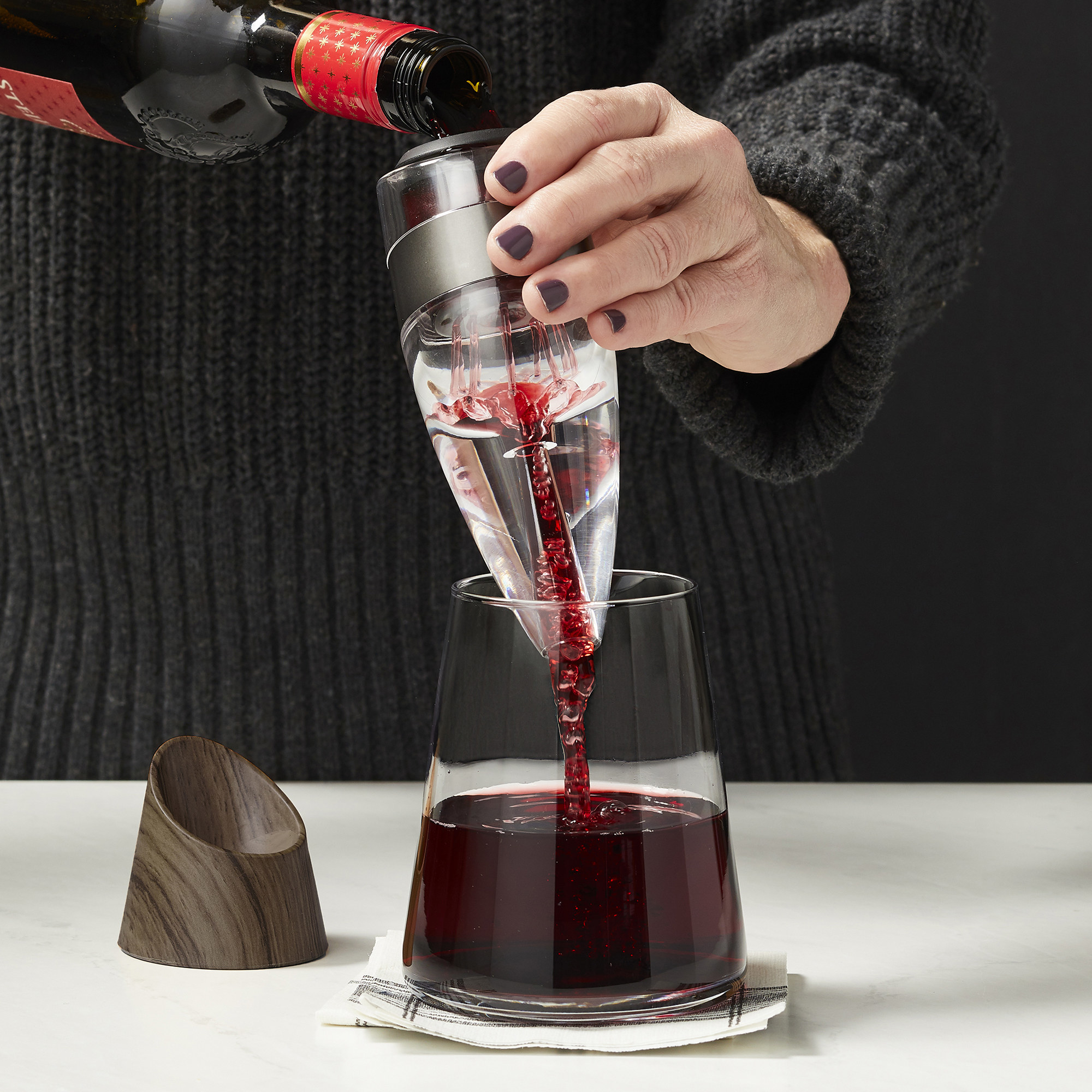 Model pouring wine through aerator into decanter