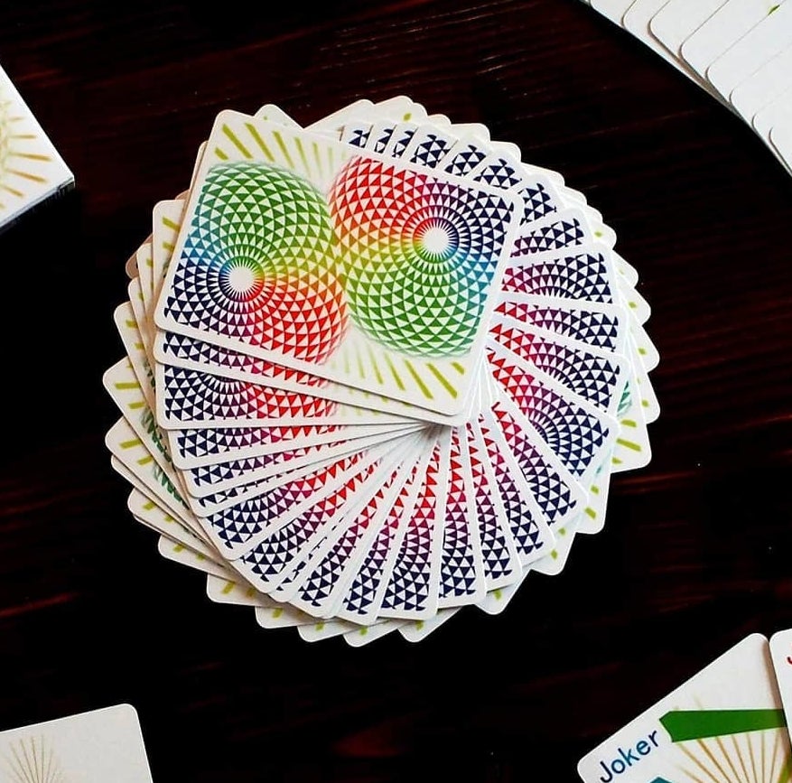 the patterned playing cards fanned out on a gaming table