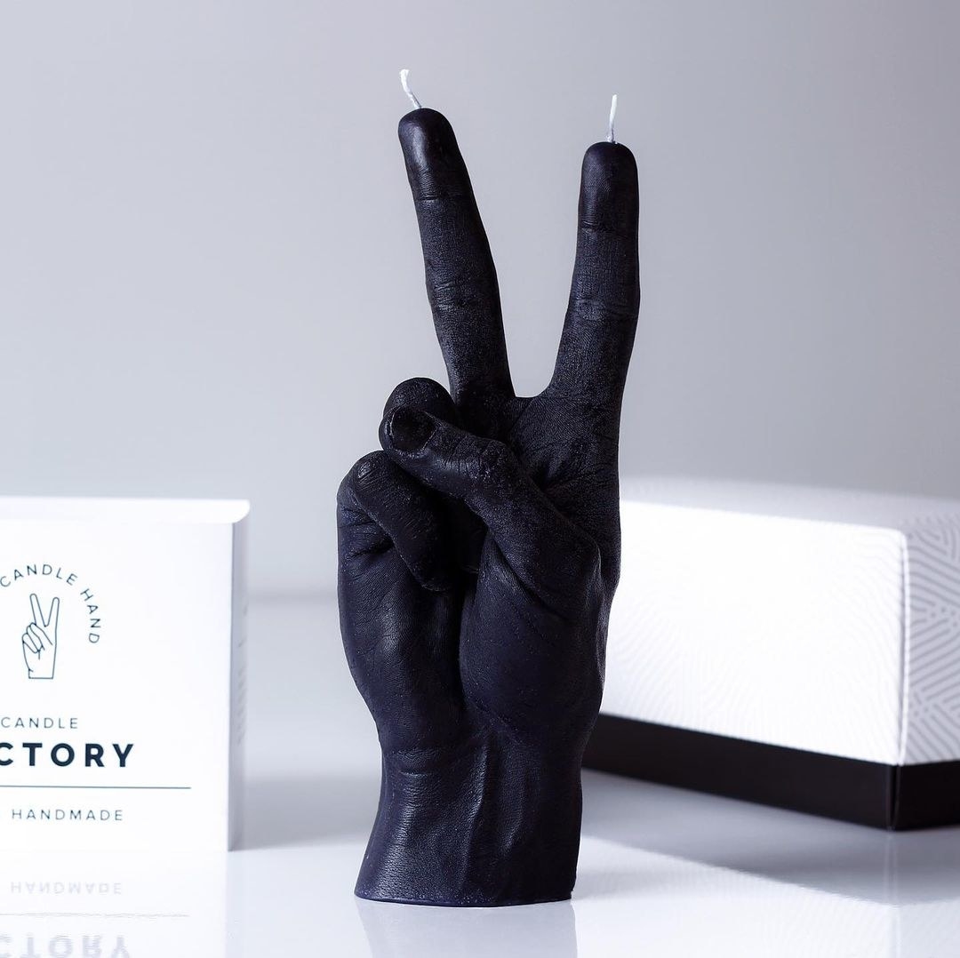 a human hand-shaped candle making a peace sign