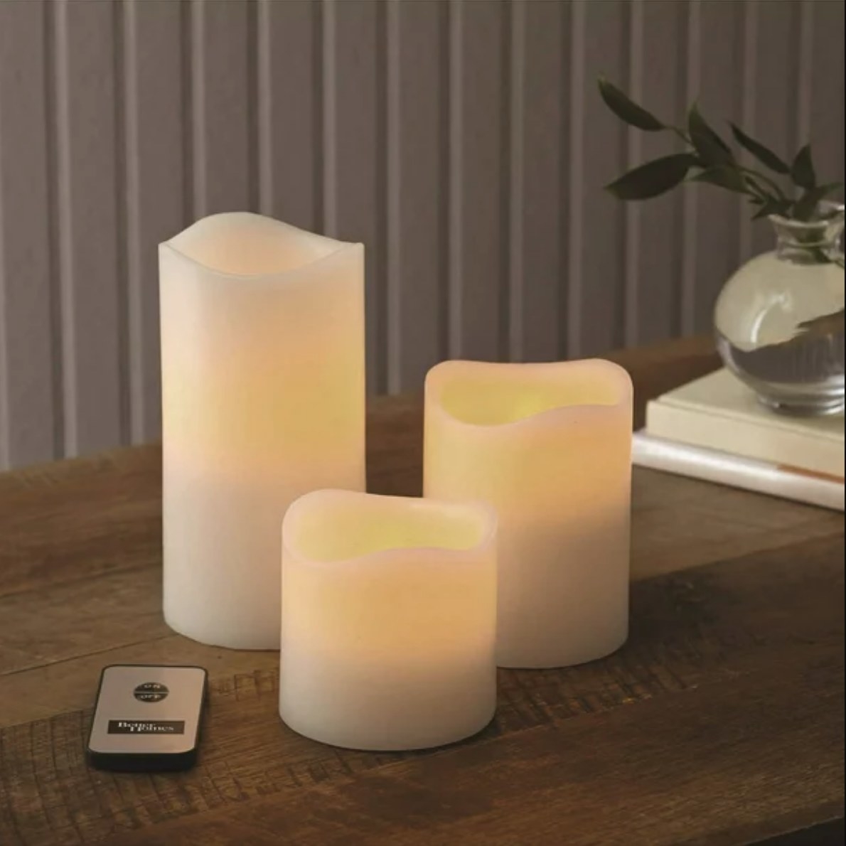 Three flameless white candles on wooden table