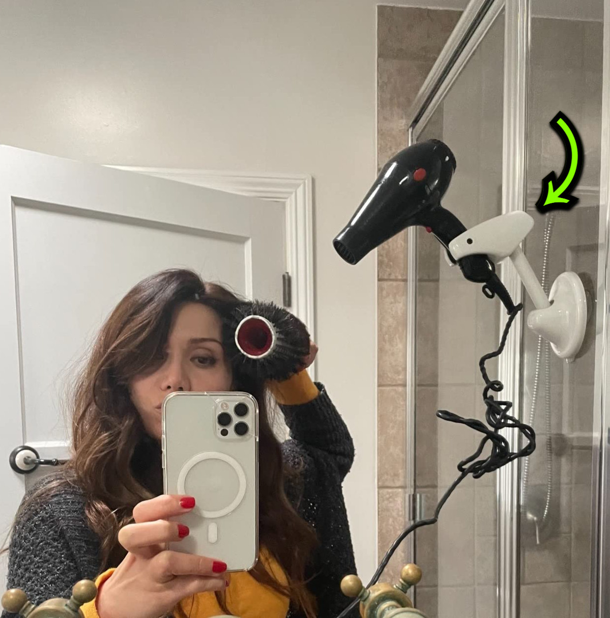 reviewer blow drying hair with a dryer placed in the holder