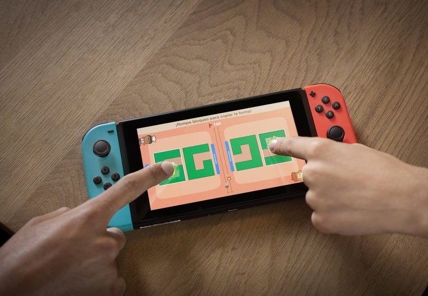 two people playing a game with the touch screen of a nintendo switch