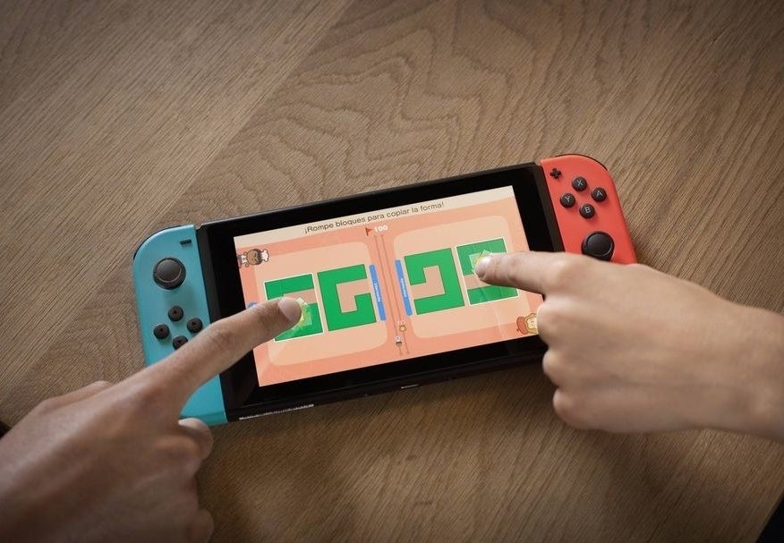 two people playing a game with the touch screen of a nintendo switch