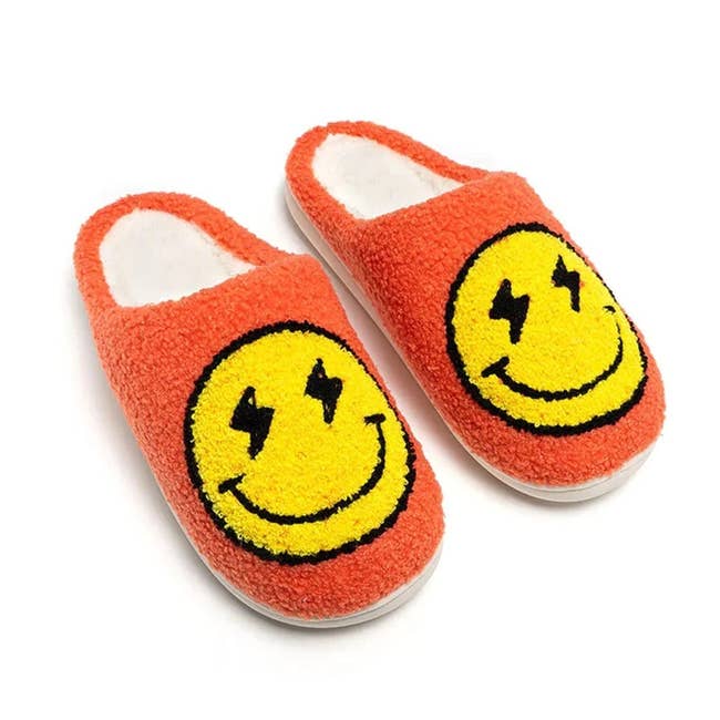 the orange slippers with smiley faces that have lightning bolts for eyes