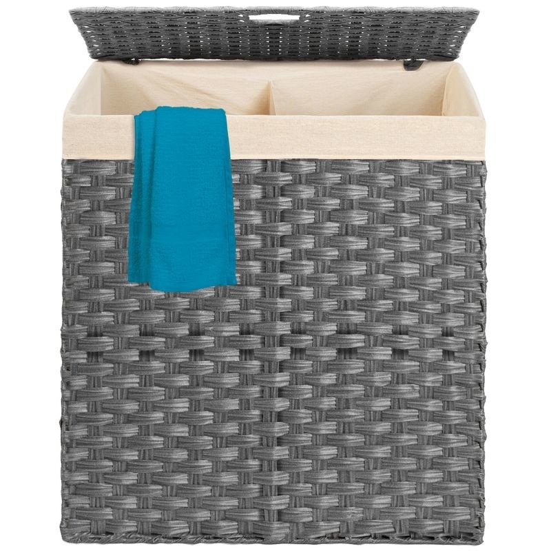 the grey divided hamper with a tan liner and blue fabric hanging partially out