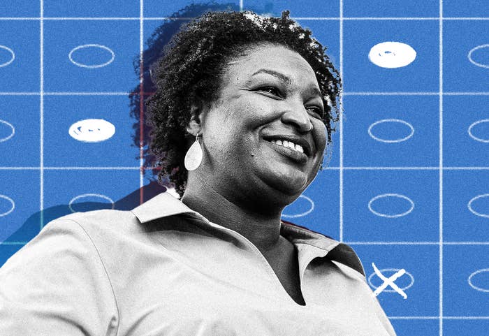 A medium close-up of Stacey Abrams in front of an illustration of ballot bubbles