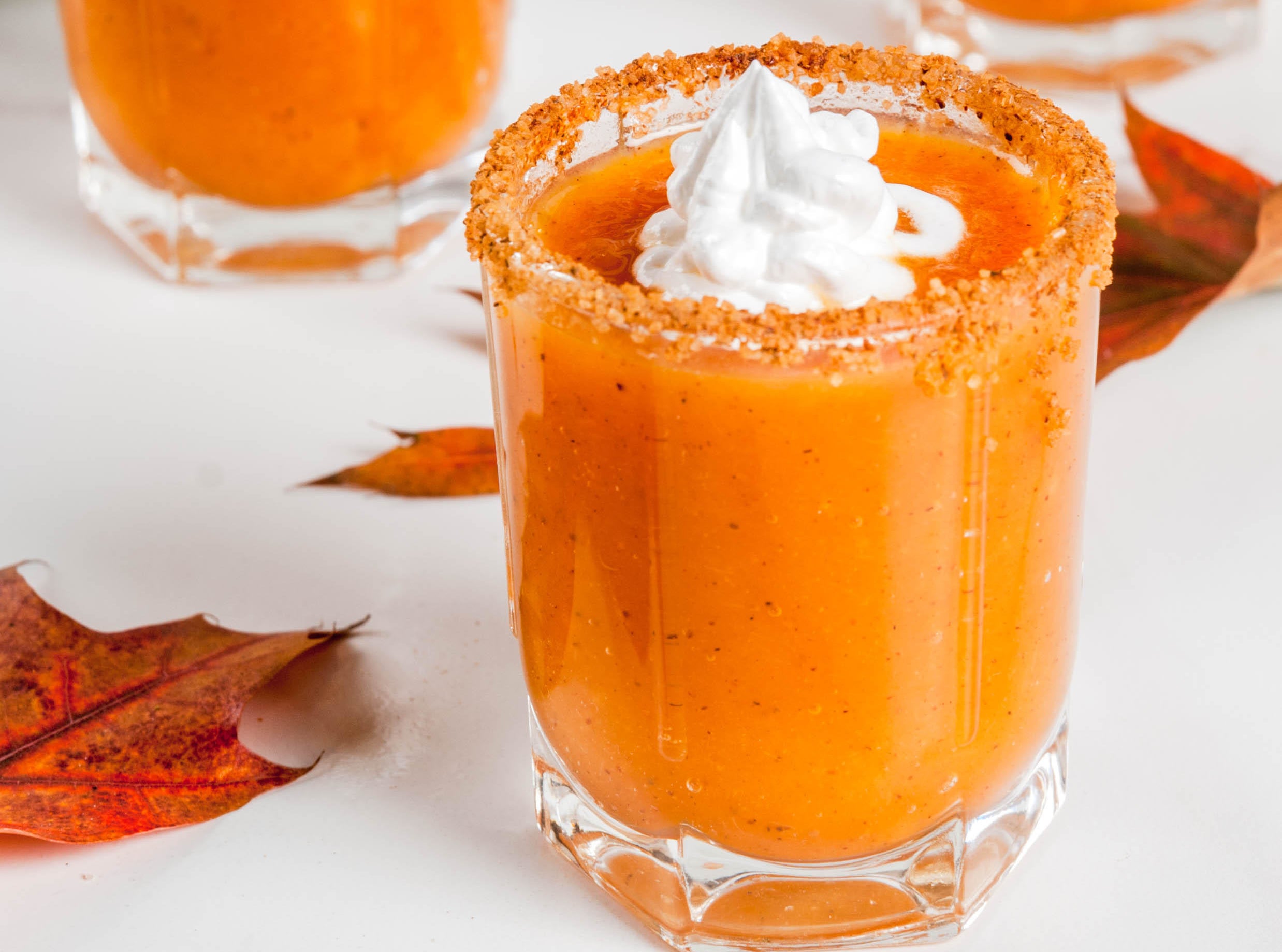 Pumpkin Pie Vodka Shots on white marble table with fall leaves